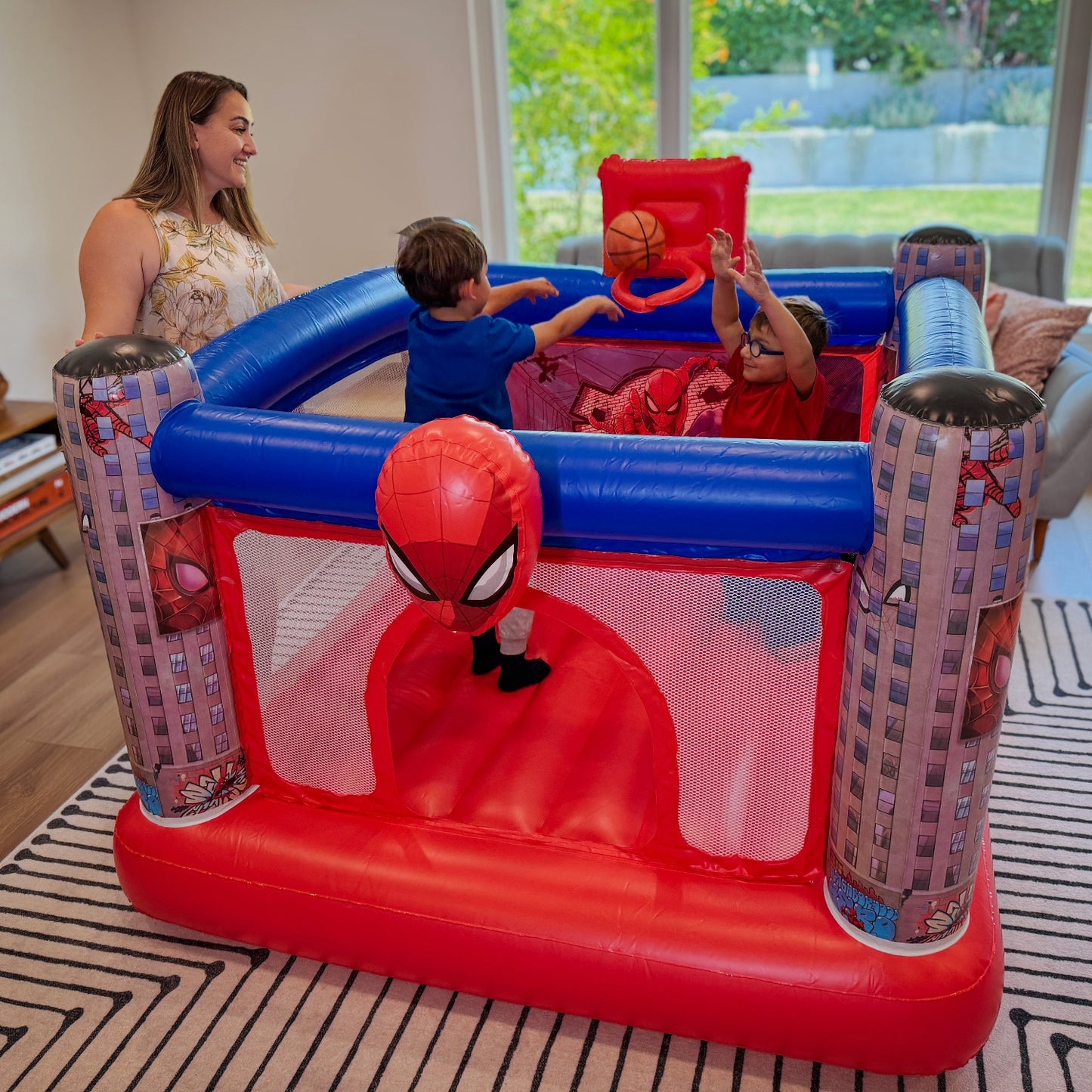 Children playing in a Spider-Man themed inflatable bounce house
