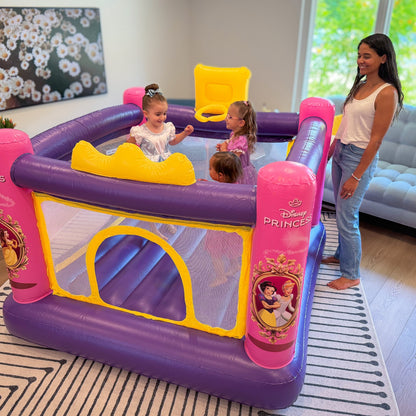 Children playing in a Disney Princess inflatable playpen with a woman supervising.